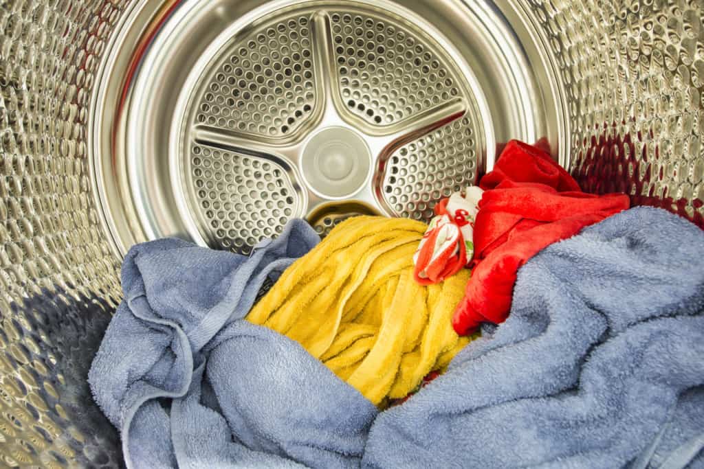 Colorful laundry inside a stainless steel washing machine drum.
